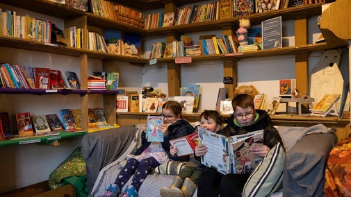 Three children sat on sofa reading in second hand bookshop at Ormesby Hall